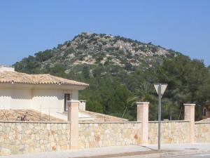 Vista del montículo en donde se asienta el Parque arqueológico Puig de sa Morisca en Nova Santa Ponsa. El chalet usa fachada con una técnica de marjada similar a la típica mallorquina, muy frecuente entre las casas de la zona.