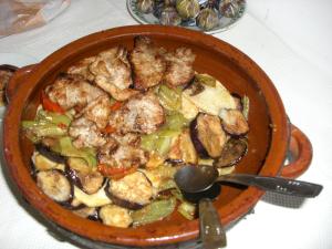 Una greixonera con tumbet, uno de los más típicos platos de la gastronomía isleña. Se compone de berenjenas fritas en aceite de oliva con pimientos rojos, finas láminas de papas y salsa de tomate