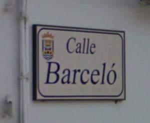 Placa que señala el nombre de una calle de la ciudad (en este caso la calle Barceló) con el escudo municipal.