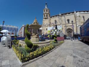 Plaza de España, fuente en primer plano y al fondo Iglesia La Asunción de Nuestra Señora. 