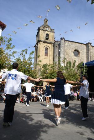 Grupo de baile catalán en San Migueles del 2008. Al fondo, la iglesia parroquial de San Miguel.