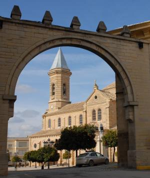 Arco, plaza de Andalucía e iglesia parroquial de Nuestra Señora de la Asunción de Porcuna