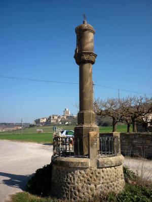 Columna de San Roc, con el castillo de Malgrat al fondo