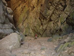 Entrada a la cueva seca con un turista para apreciar tamaño.