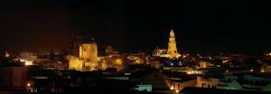 Vista nocturna de Utrera desde la plaza de España. Se aprecian: a la izquierda el Castillo, detrás la torre de la iglesia de Santiago y la iglesia de Santa María de la Mesa a la derecha