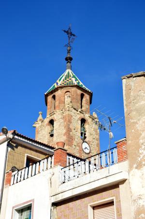Vista parcial (suroccidental) de la torre-campanario de la iglesia parroquial de la Natividad en Tormón (Teruel), desde la Plaza (2017).