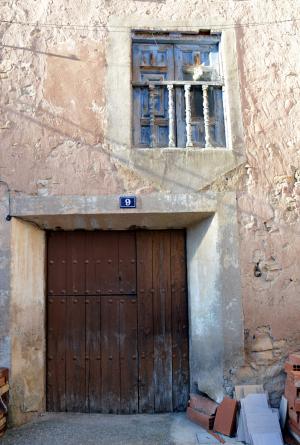 Detalle de entrada y ventana-balcón en la fachada de una casa de Tormón (Teruel), muestra de arquitectura vernácula (2017).