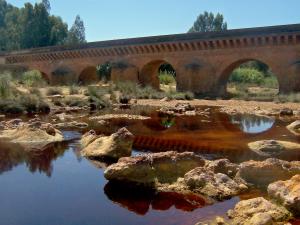 Puente romano de Niebla sobre las aguas del Río Tinto
